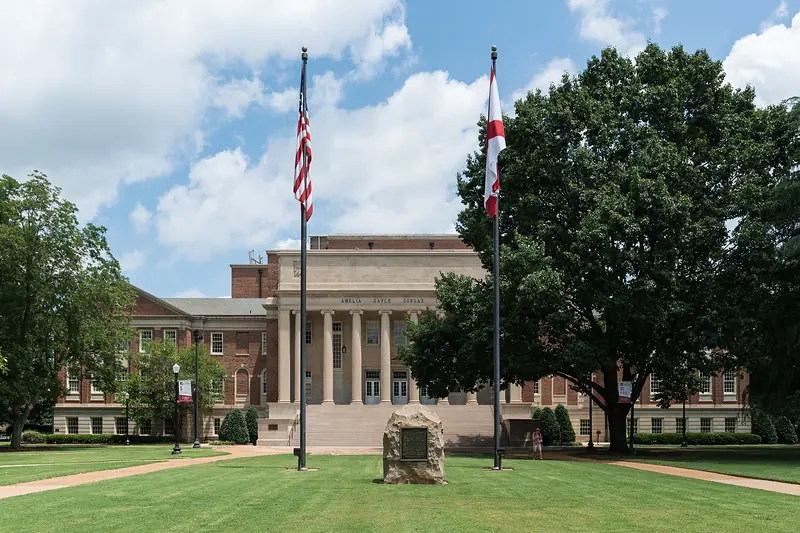 Amelia Gayle Gorgas Library at The University of Alabama in Tuscaloosa, with two flagpoles in front.